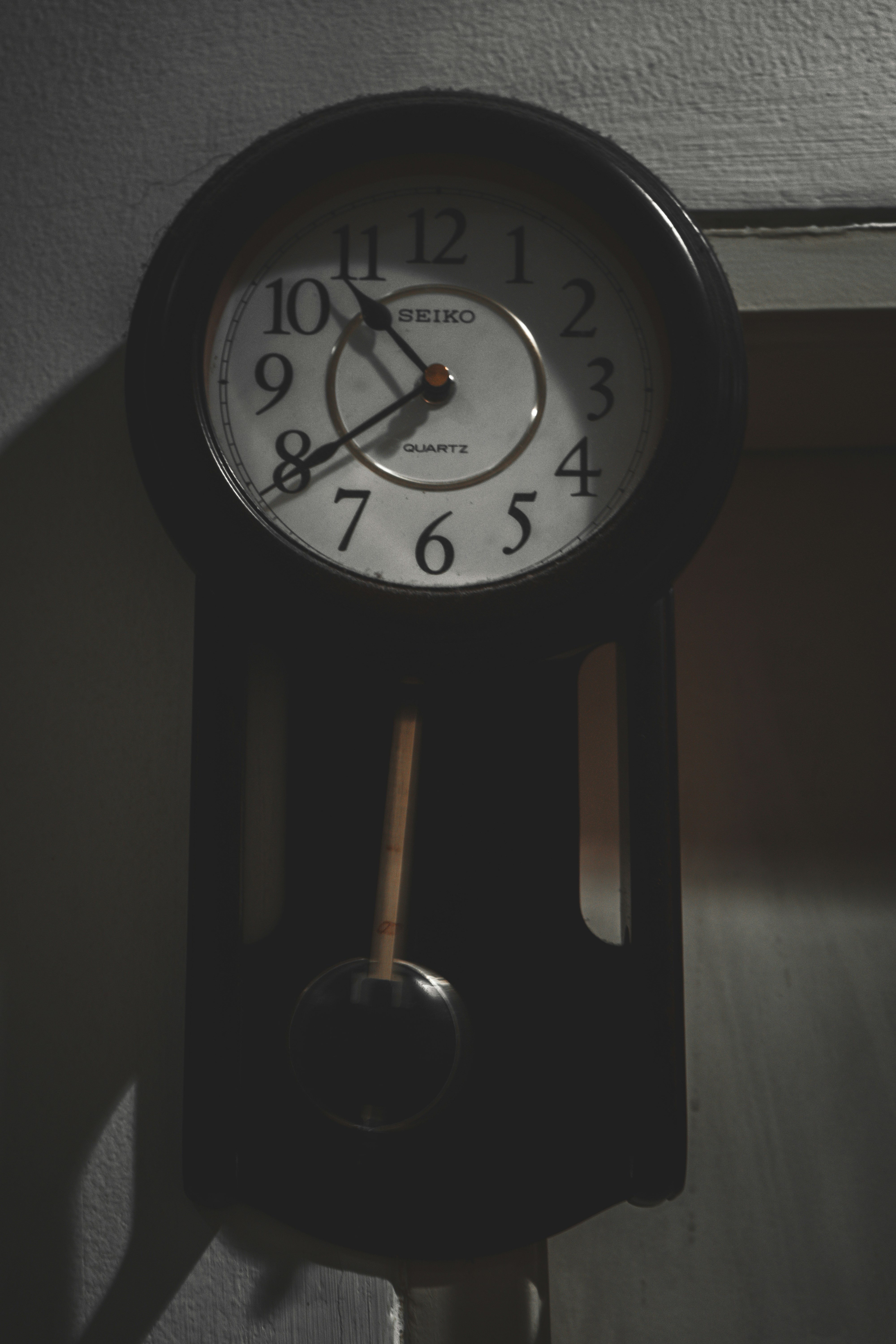 a black clock with a white face on a wall