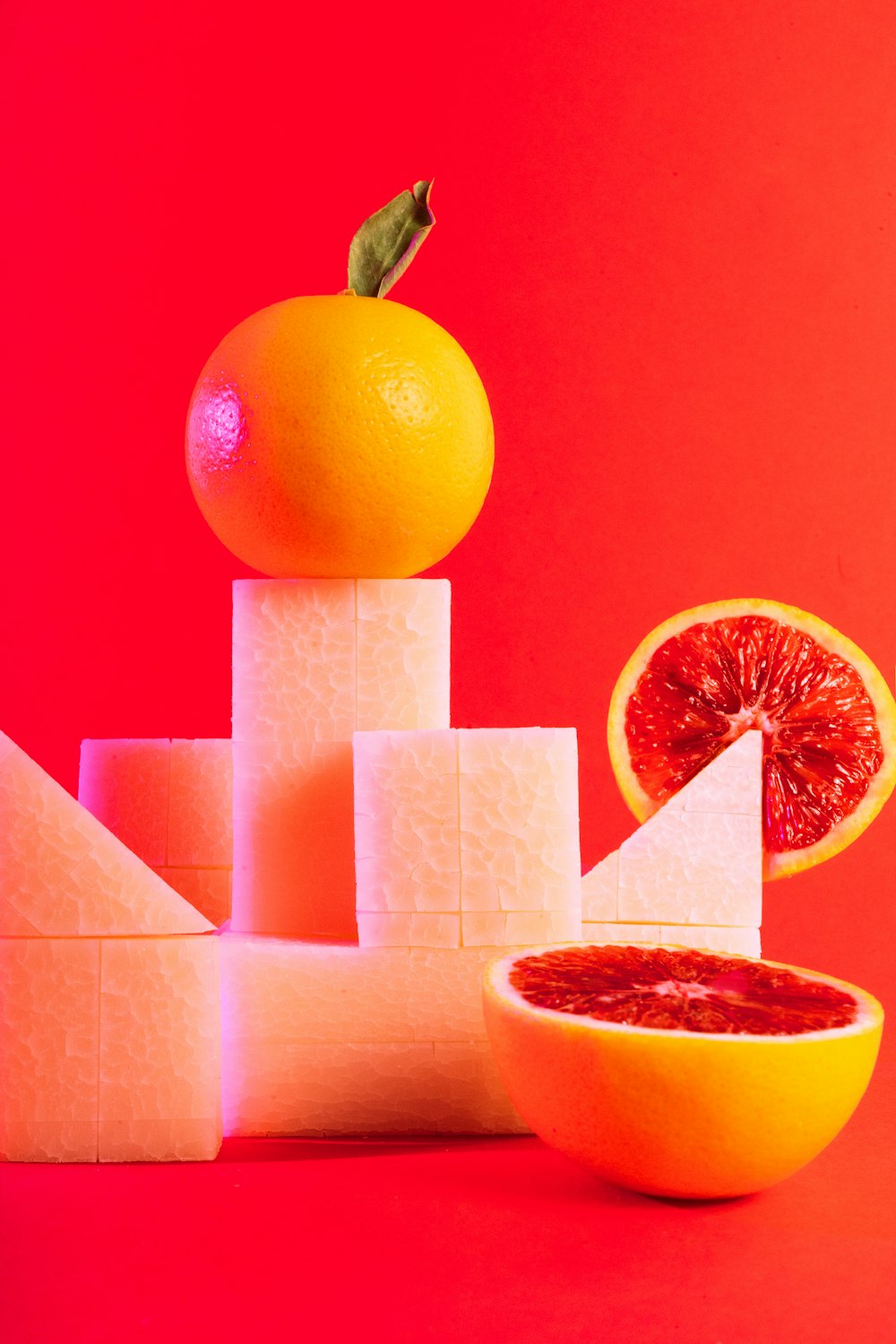 a grapefruit and a piece of cheese stacked on top of each other