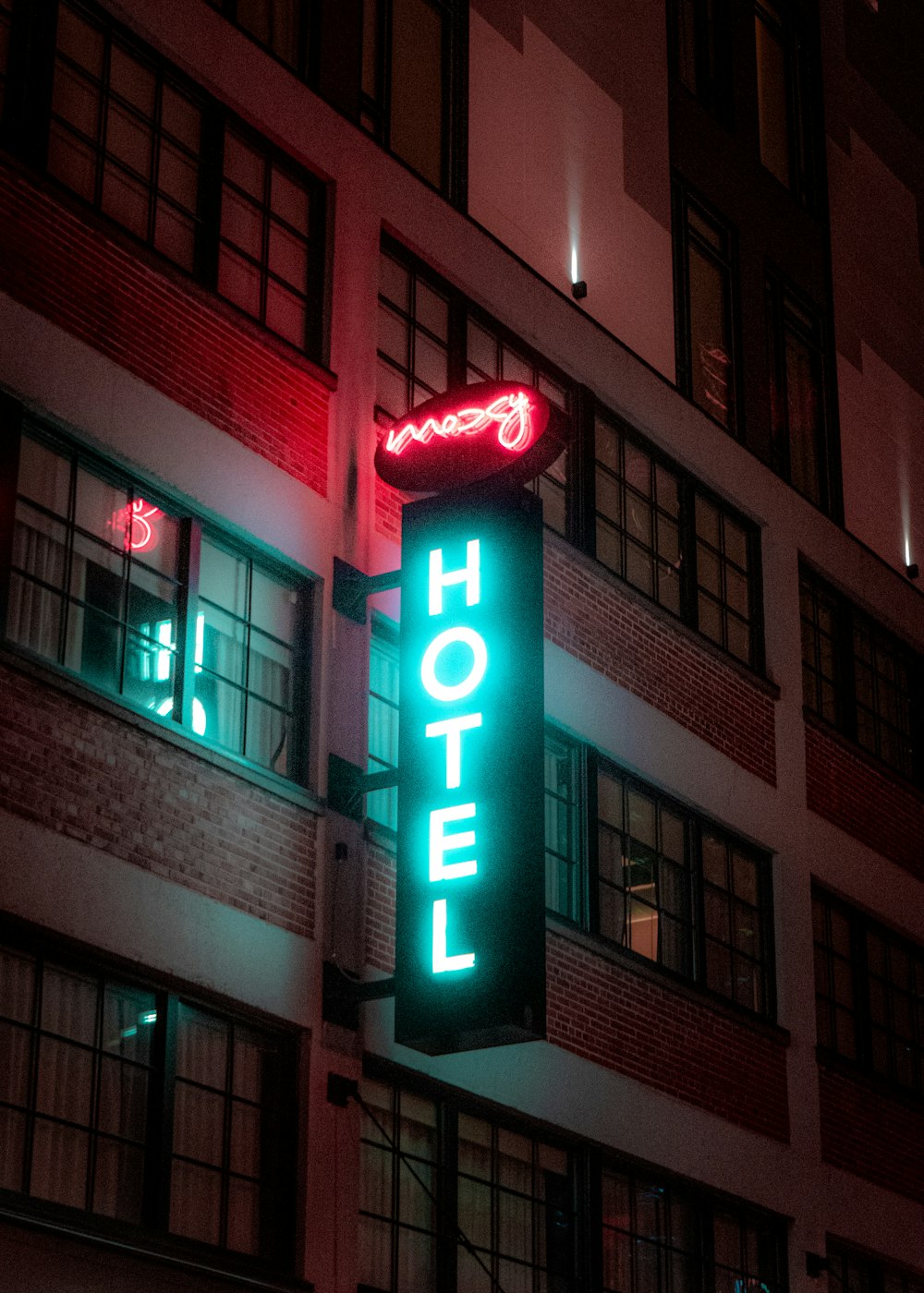 a hotel sign lit up at night in front of a building