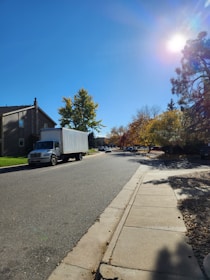 A ClearOut Pros truck driving away from a clean, clutter-free residential driveway on a sunny day.
