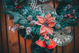 A festive Christmas floral centerpiece with pine cones and red berries.