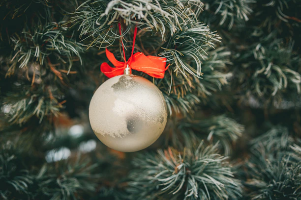 Close-up of a beautifully aged Christmas ornament hanging on a rustic pine branch.