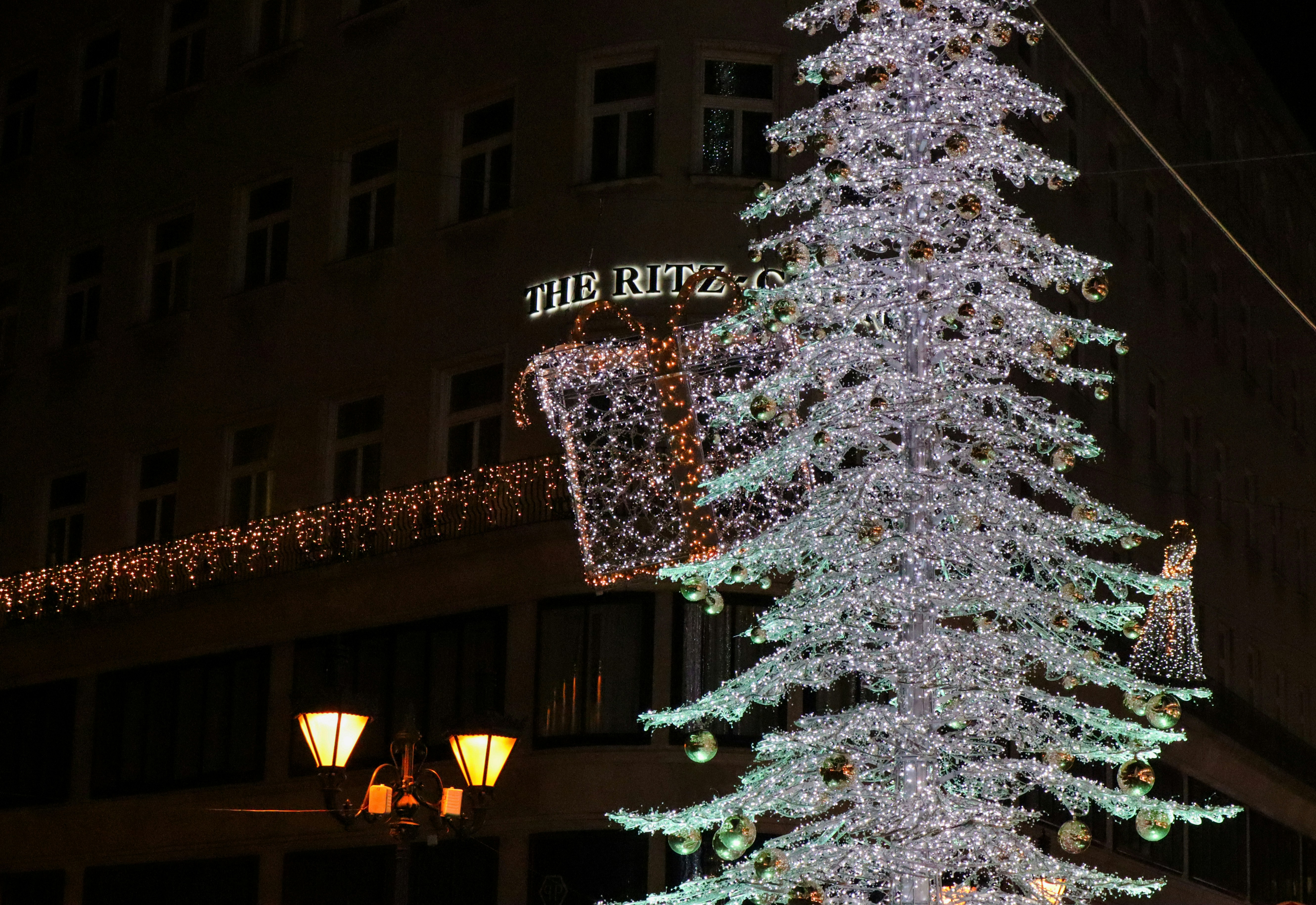 a lit christmas tree in front of a building