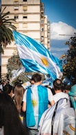 a group of people walking down a street holding flags