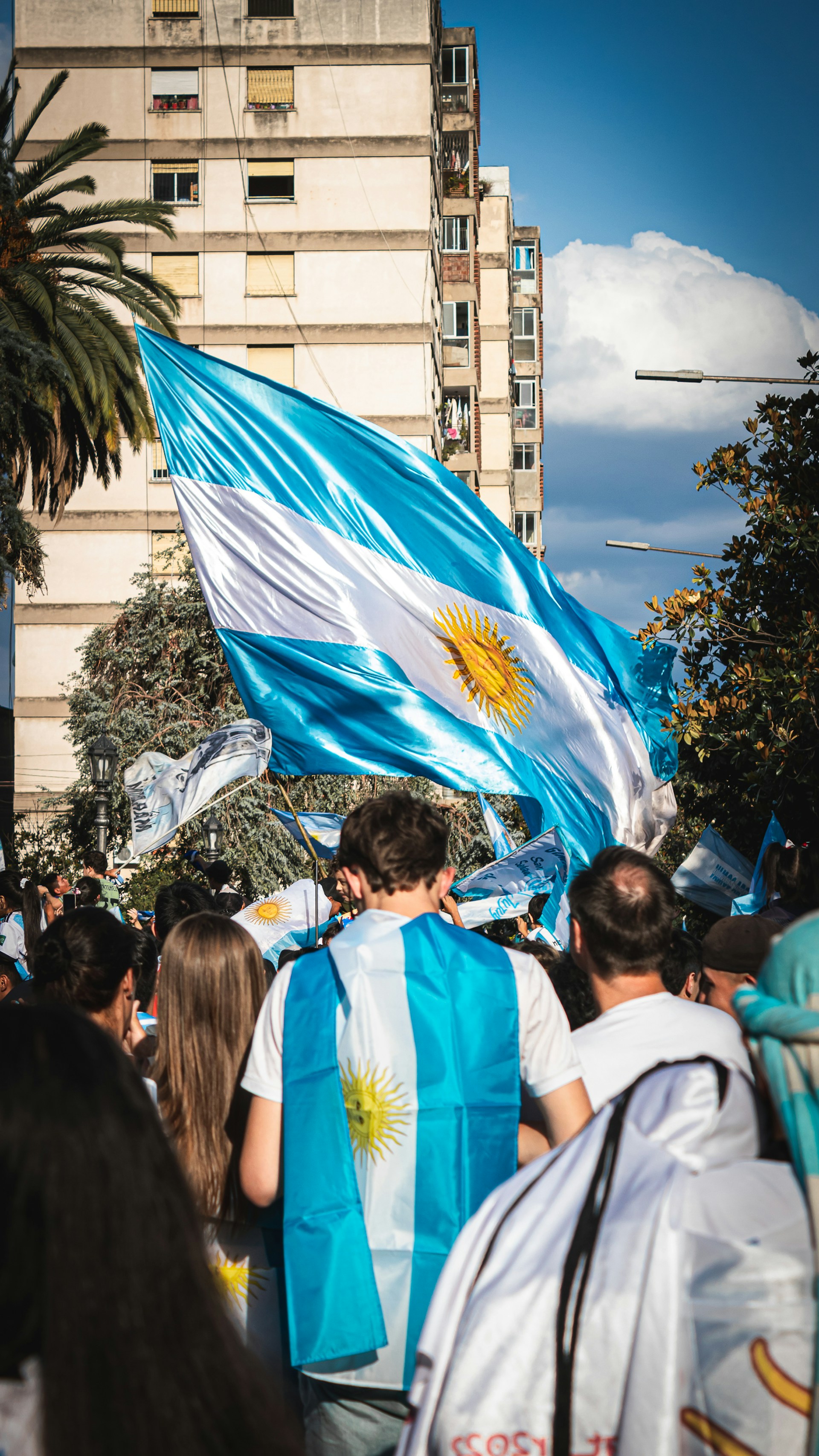 a group of people walking down a street holding flags