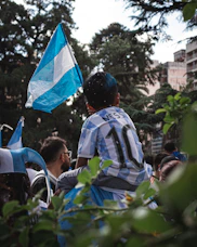a young boy holding a blue and white flag