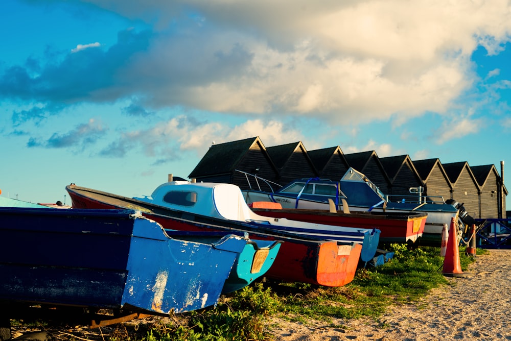 a row of boats sitting on top of a sandy beach