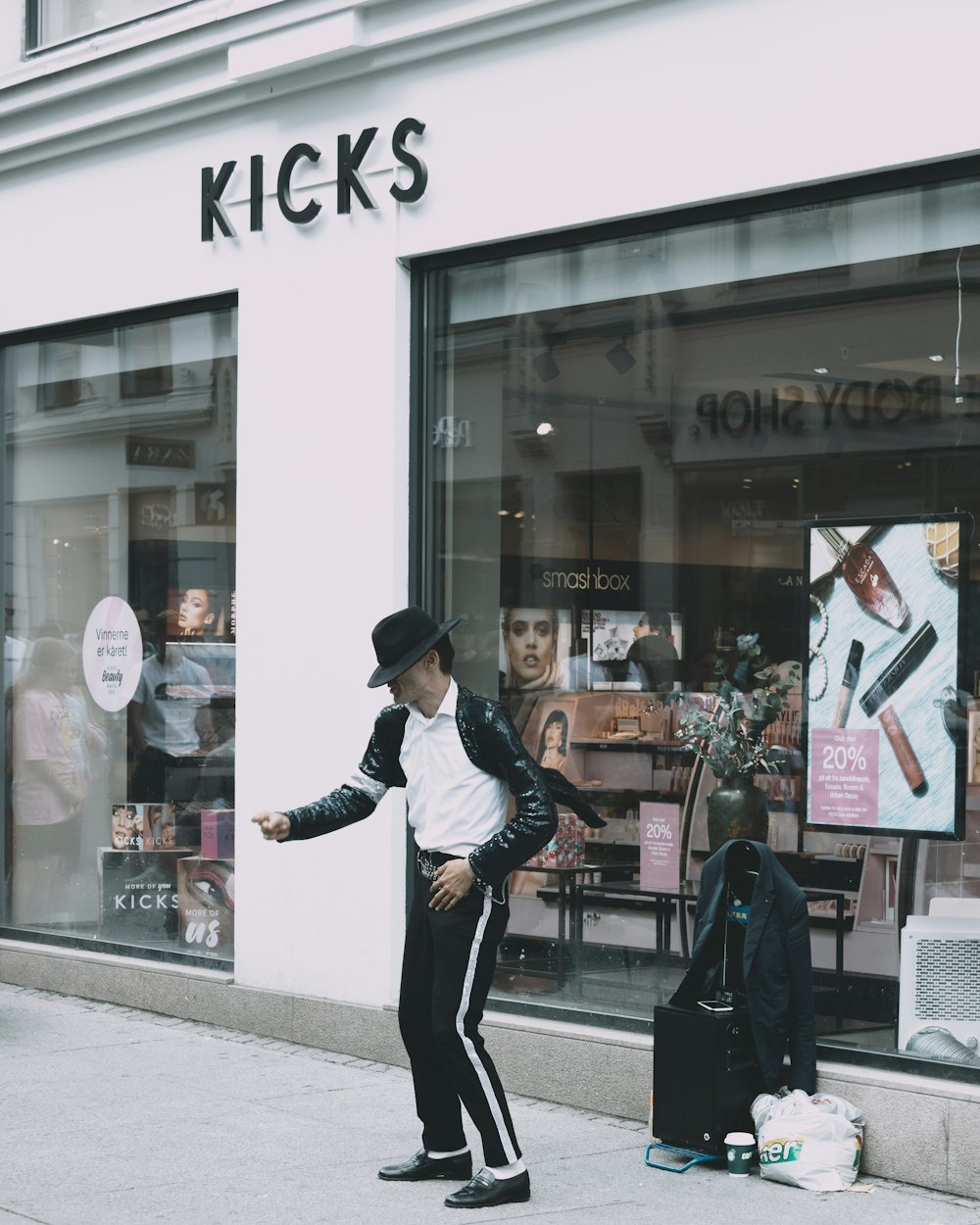 a man standing on a sidewalk in front of a store