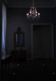 A dimly lit, elegant room set up for a private dominatrix session.