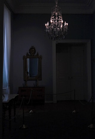 Dimly lit room with elegant black leather restraints and ritualistic candles casting warm shadows.