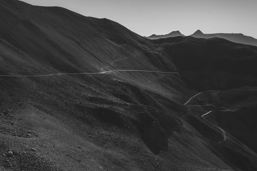 a black and white photo of a mountain road