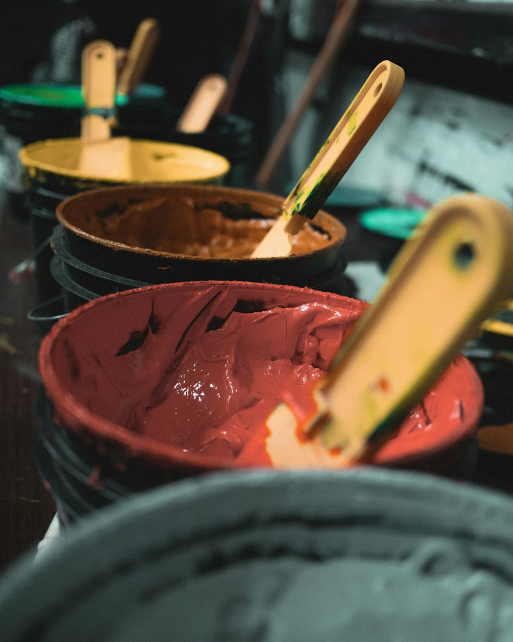 a table topped with lots of buckets filled with paint