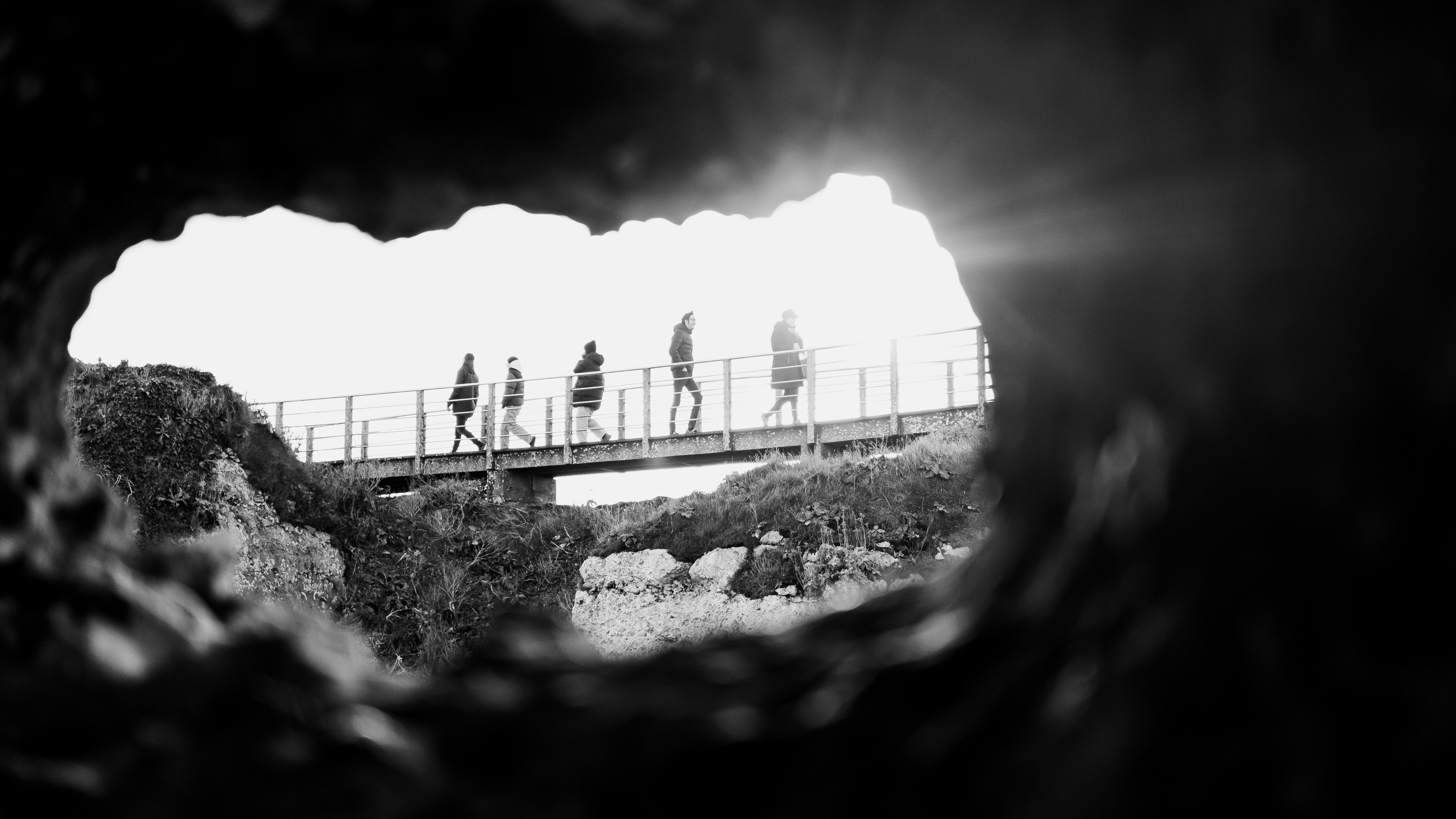 A group of people walking across a bridge photo – Free Person Image on ...