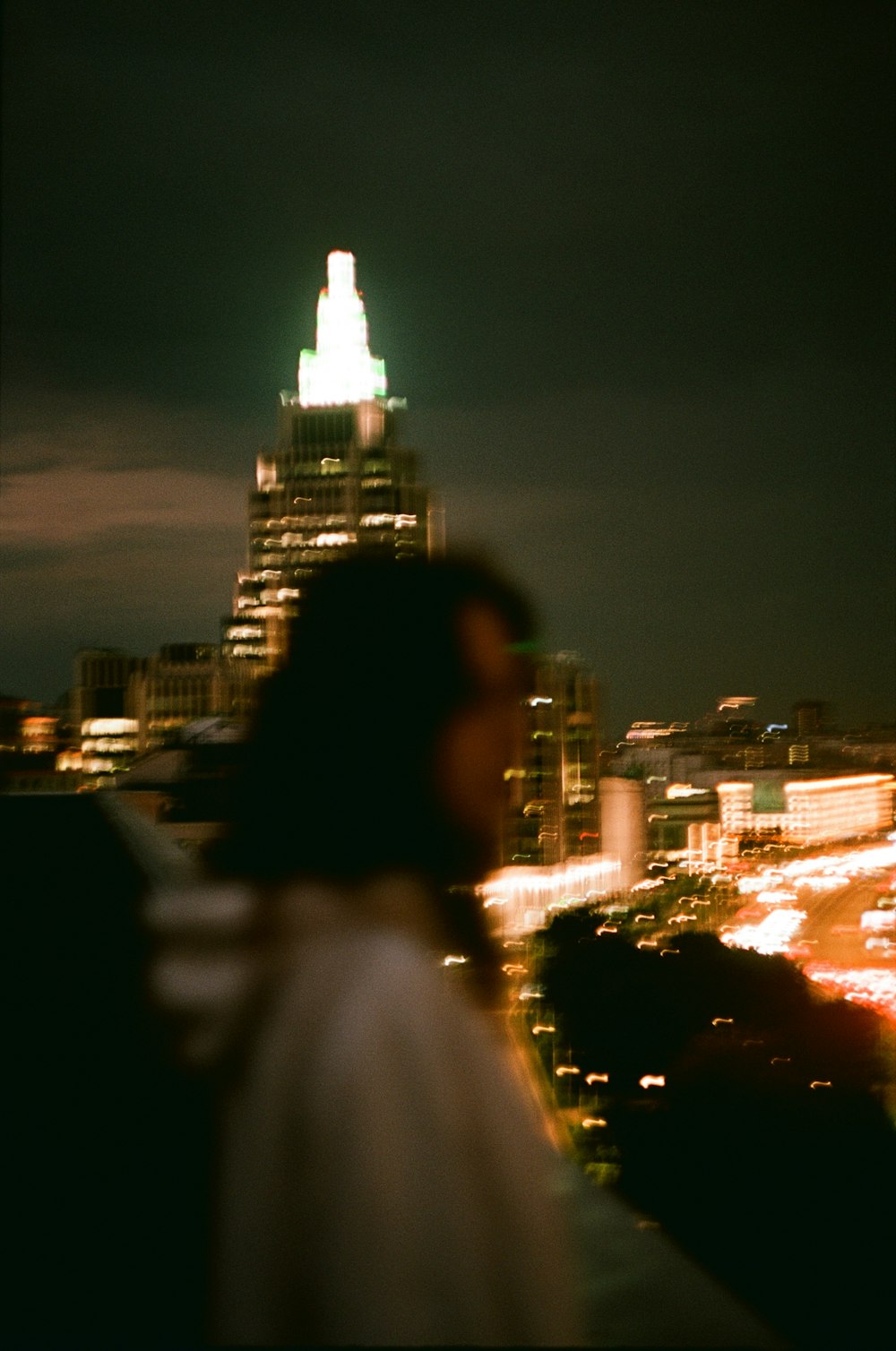 a woman standing on top of a building at night