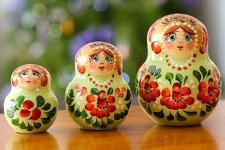 a group of three nesting dolls sitting on top of a wooden table