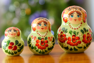 a group of three nesting dolls sitting on top of a wooden table