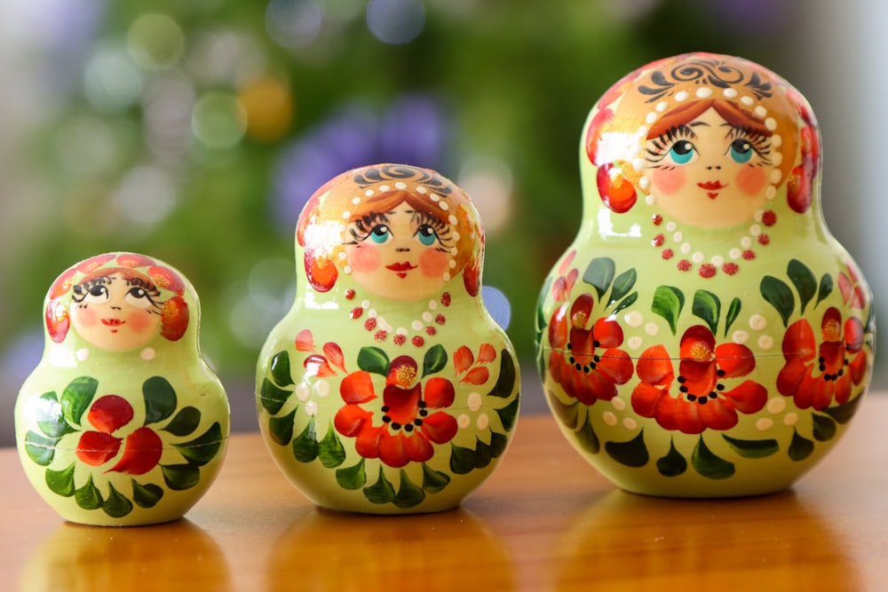 a group of three nesting dolls sitting on top of a wooden table