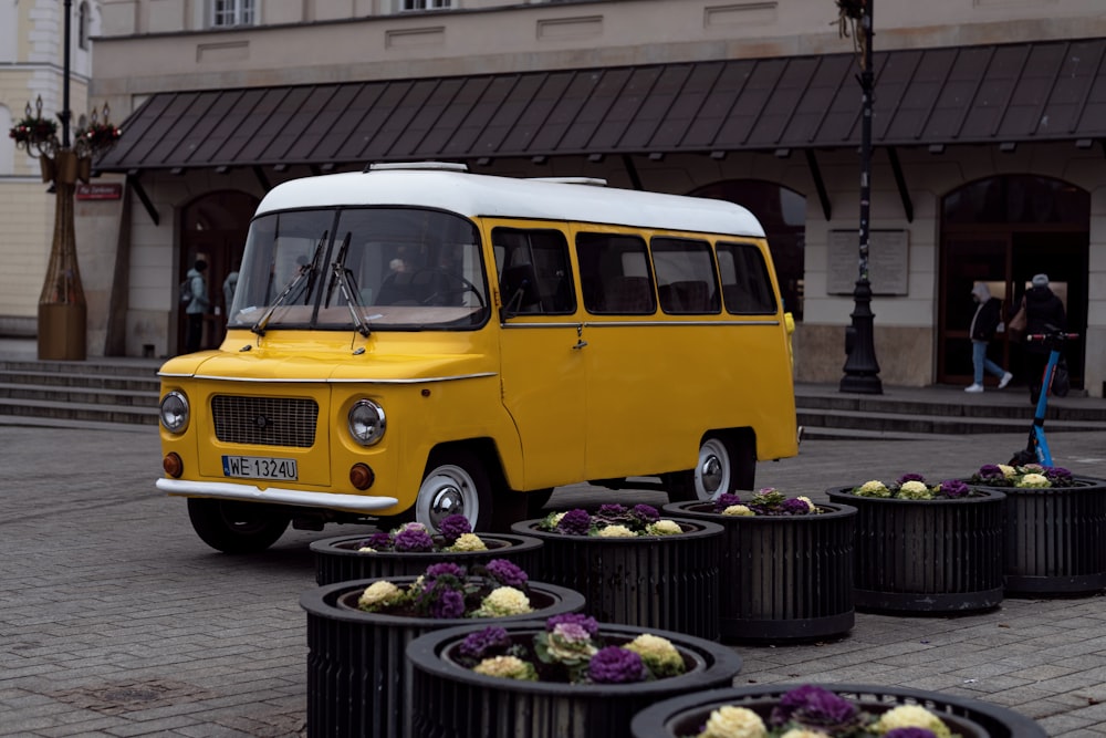 a yellow and white bus parked in front of a building