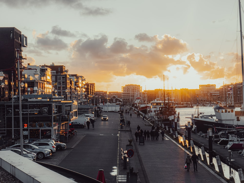 a group of people walking down a street next to a body of water