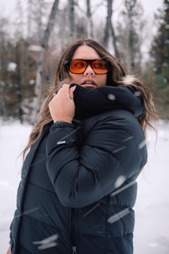 Model wearing a comfy, oversized jacket standing in a snowy park.