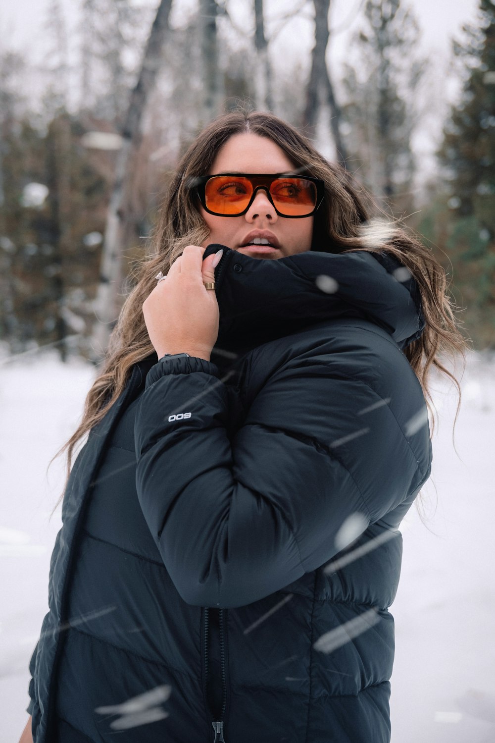 una donna che porta occhiali da sole in piedi nella neve