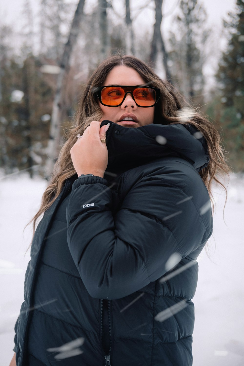 Eine Frau mit Sonnenbrille steht im Schnee