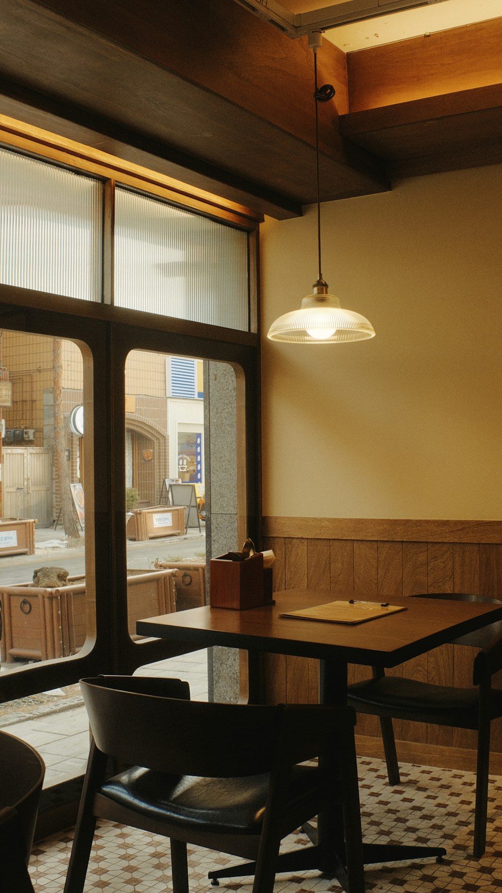 a table and chairs in a room with large windows