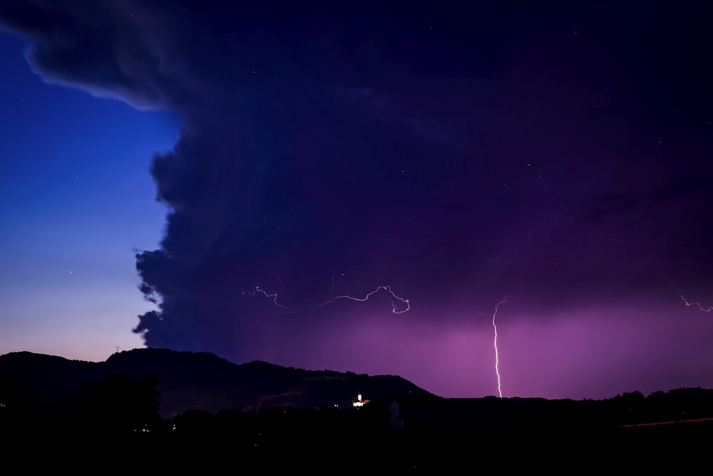 a purple sky with a lightning bolt in the distance