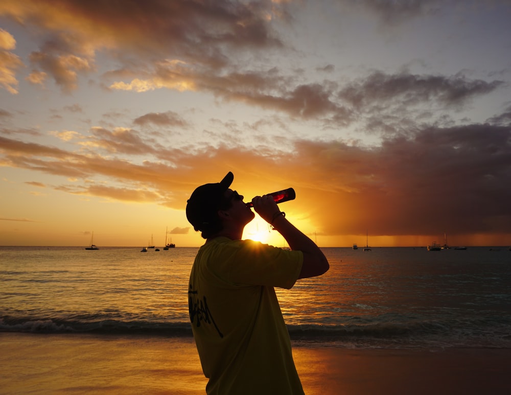 a man standing on top of a beach next to the ocean