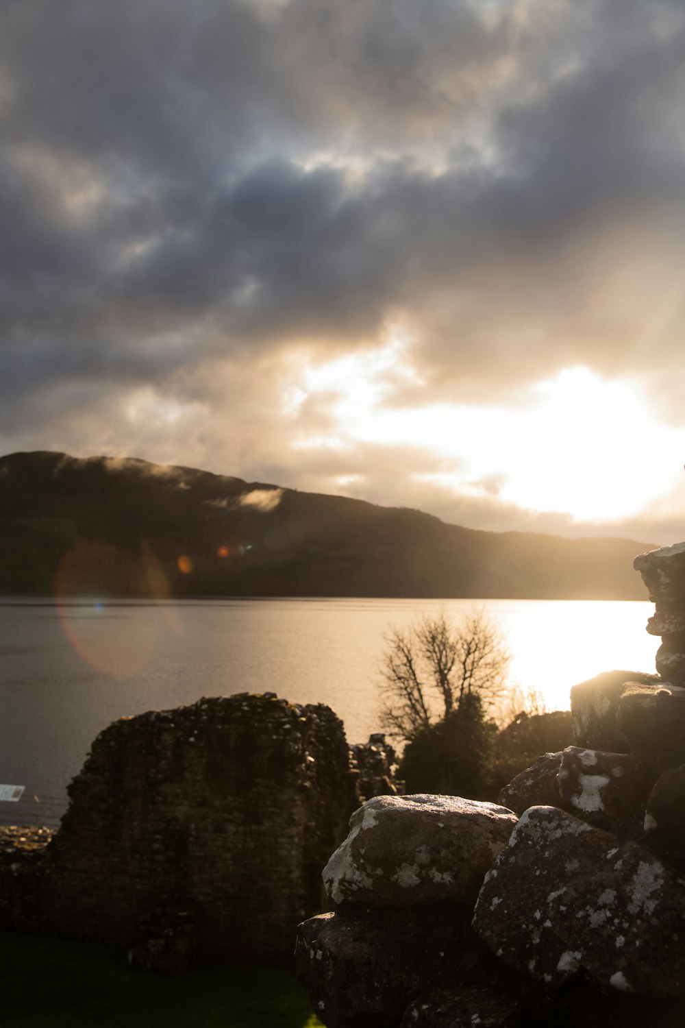 the sun shines through the clouds over a body of water