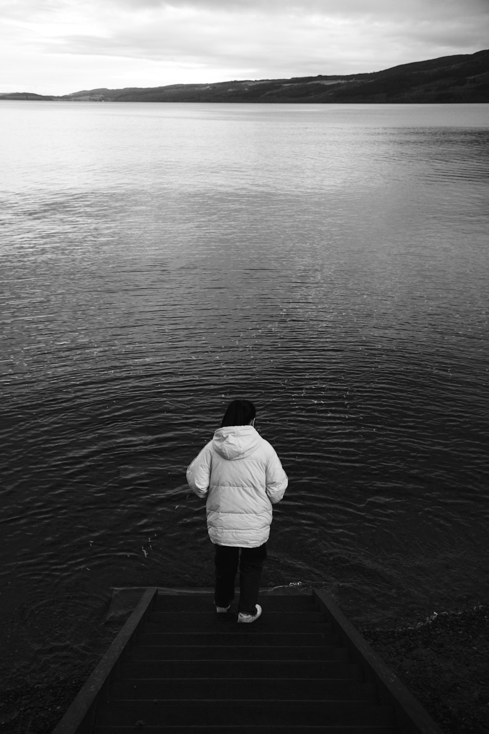 a person standing on a dock looking at the water