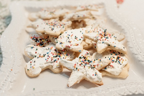 Close-up of beautifully decorated pastel-colored cookies arranged on a white plate.