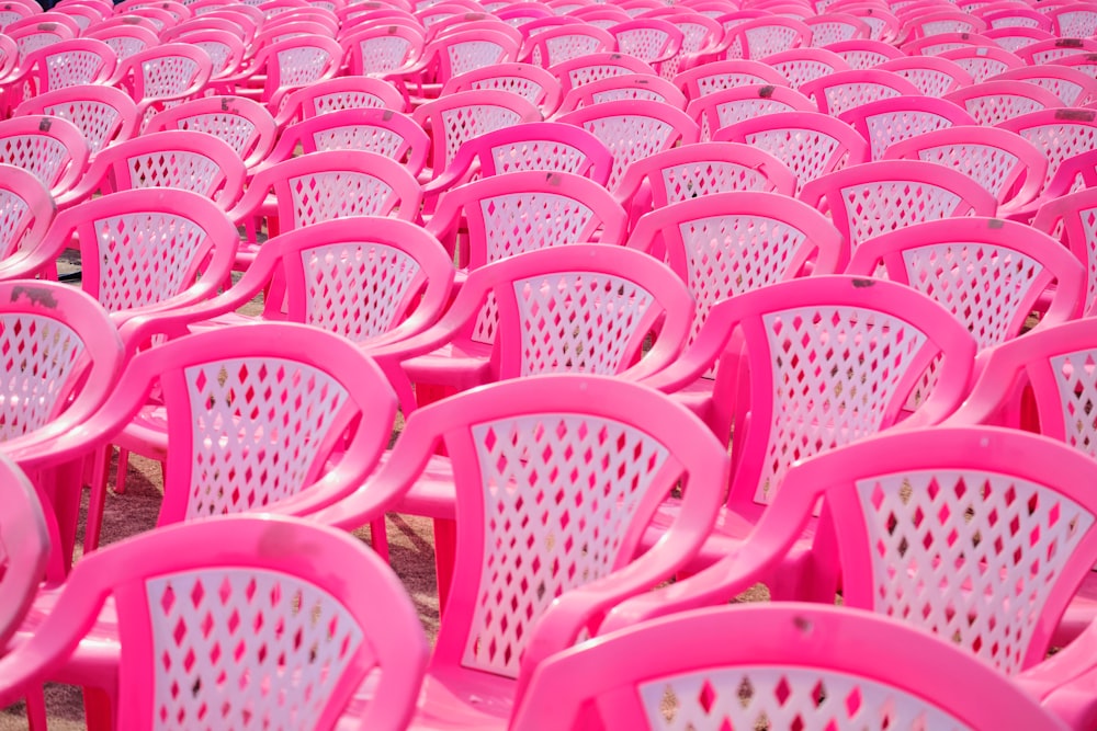 a row of pink plastic chairs sitting next to each other