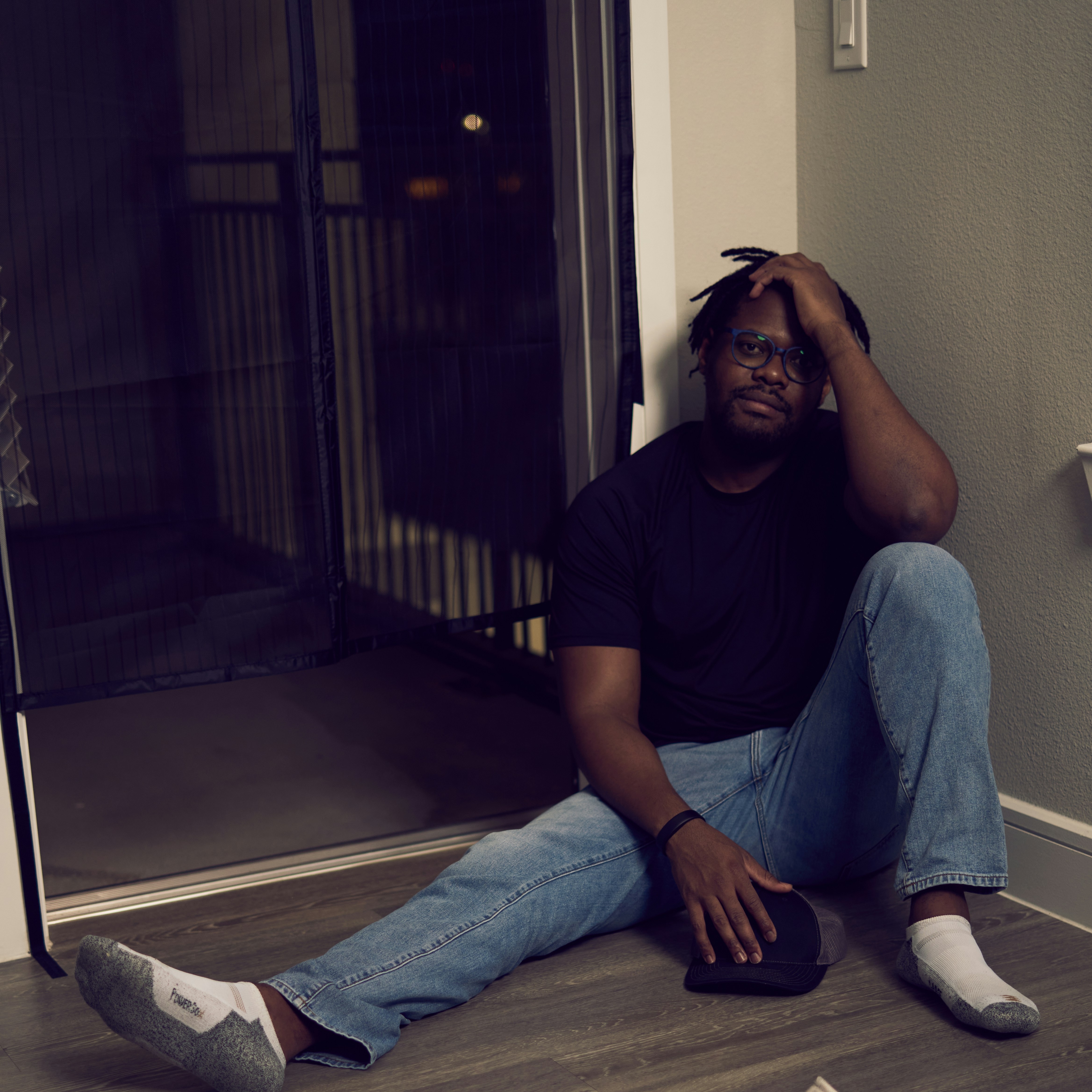 a man sitting on the floor with his head in his hands