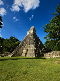 A stunning architectural view of a large pyramid structure surrounded by lush greenery.