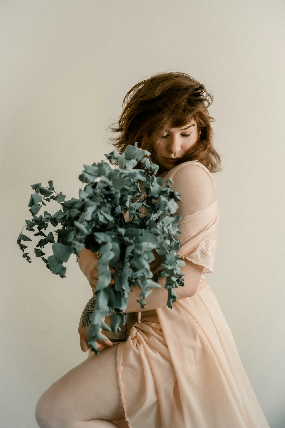 a woman in a dress holding a plant