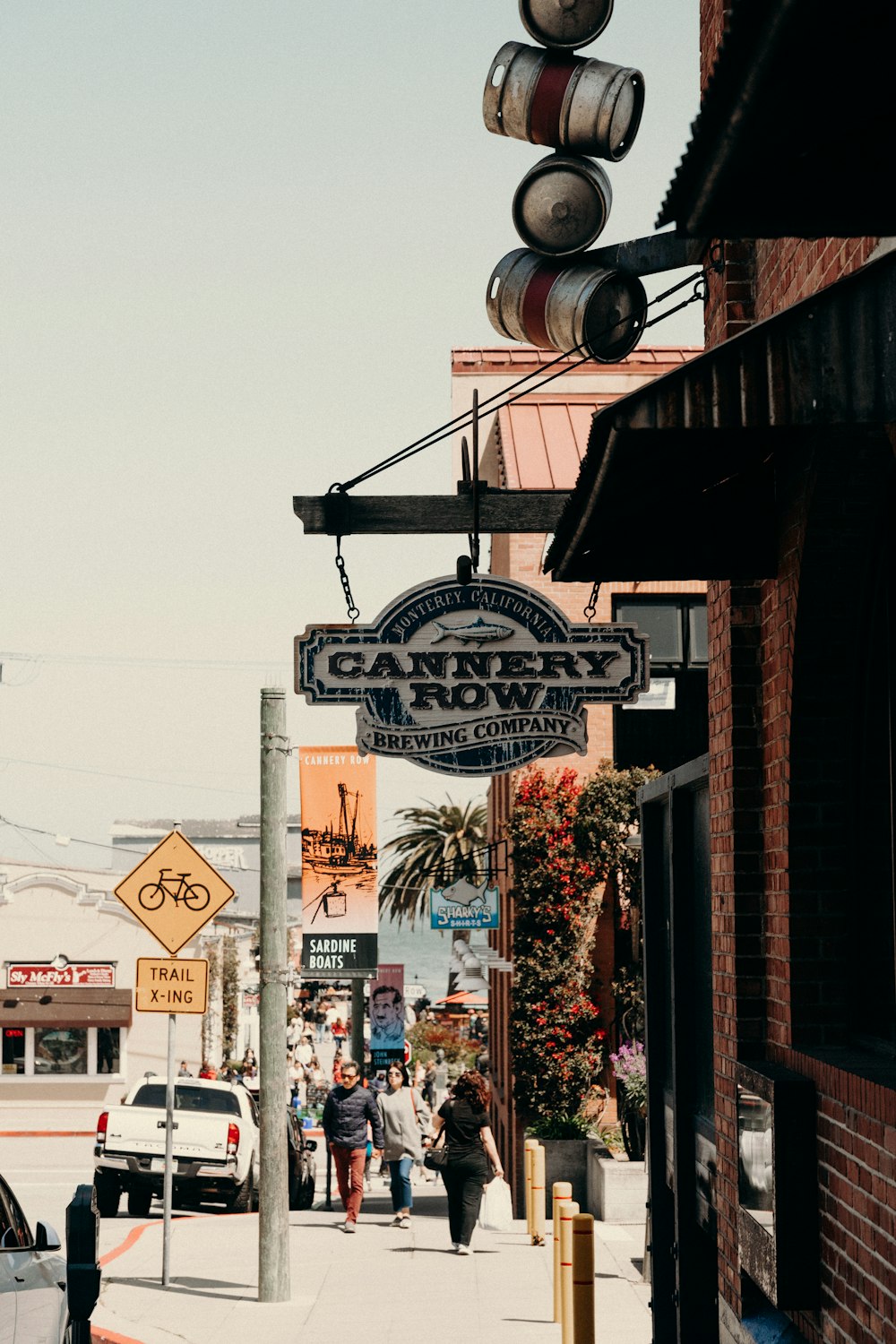 a city street with people walking and cars parked on the side of the road