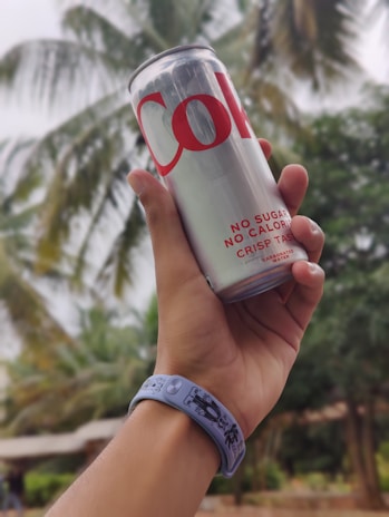 Close-up of a hand grabbing a cold beverage from a colorful Caribe Cooler.