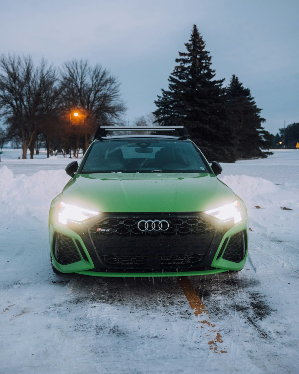 a green car is parked in the snow
