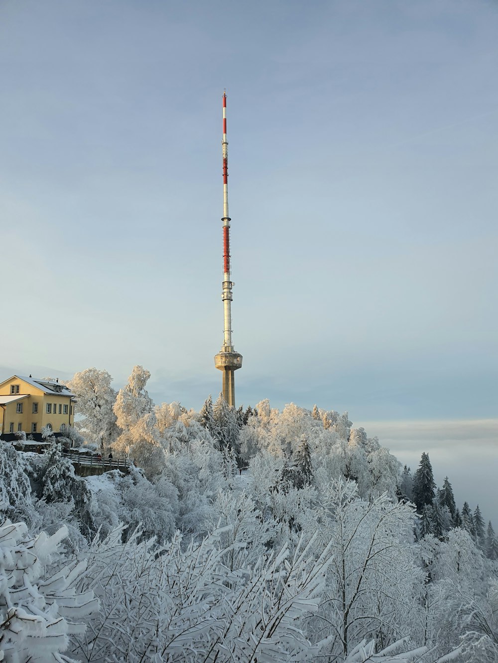 a radio tower on top of a hill covered in snow