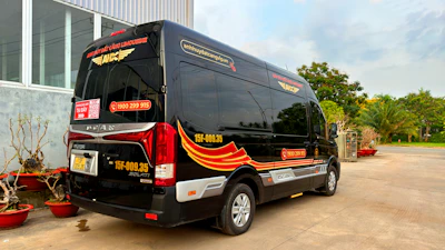 Sleek black 8-seater minibus parked outside a premium golf course at sunrise.