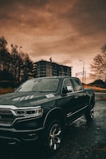 Jake's tow truck parked by a city street under a cloudy sky at dusk.