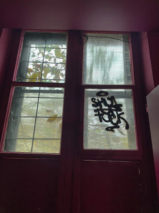Two-leaf window in a vibrant red shade with clear glass panels.