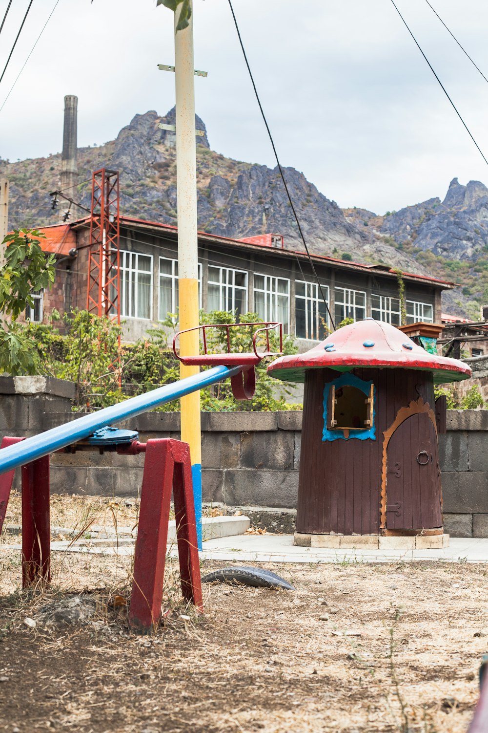 a playground with a slide and a building in the background
