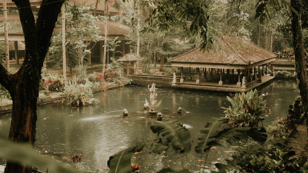 a pond surrounded by trees and a gazebo