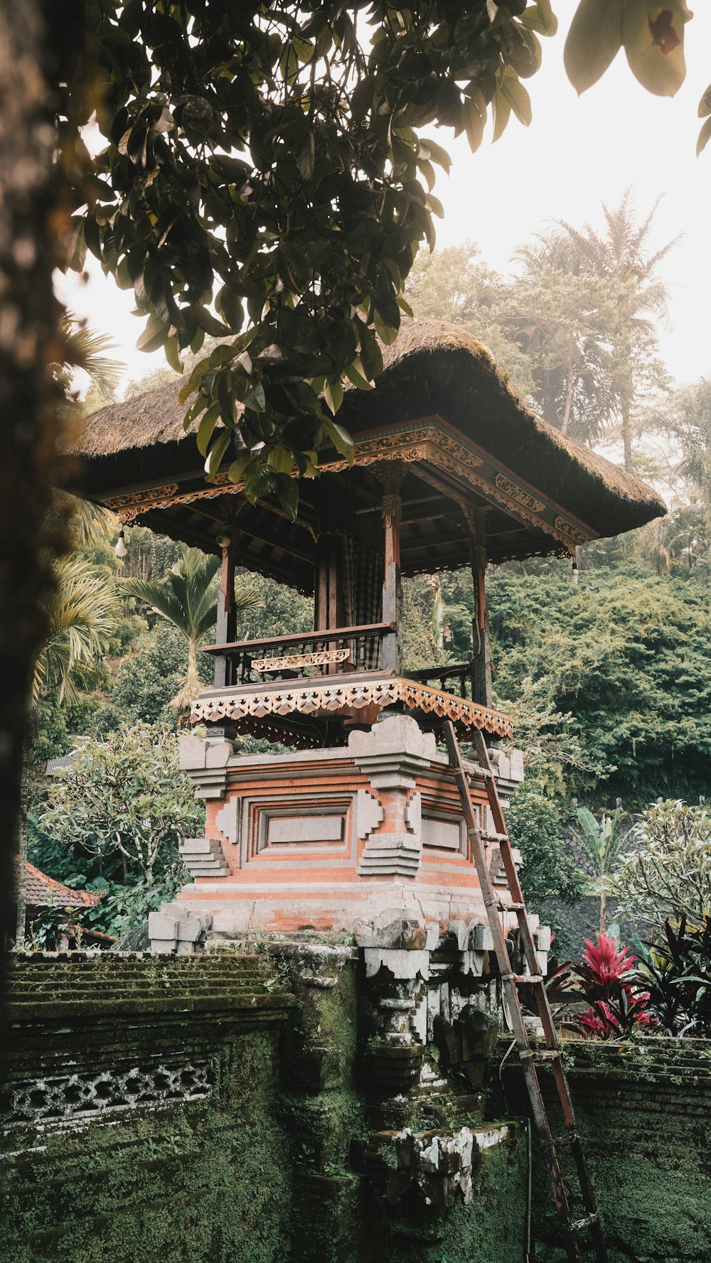 a tall tower sitting next to a lush green forest