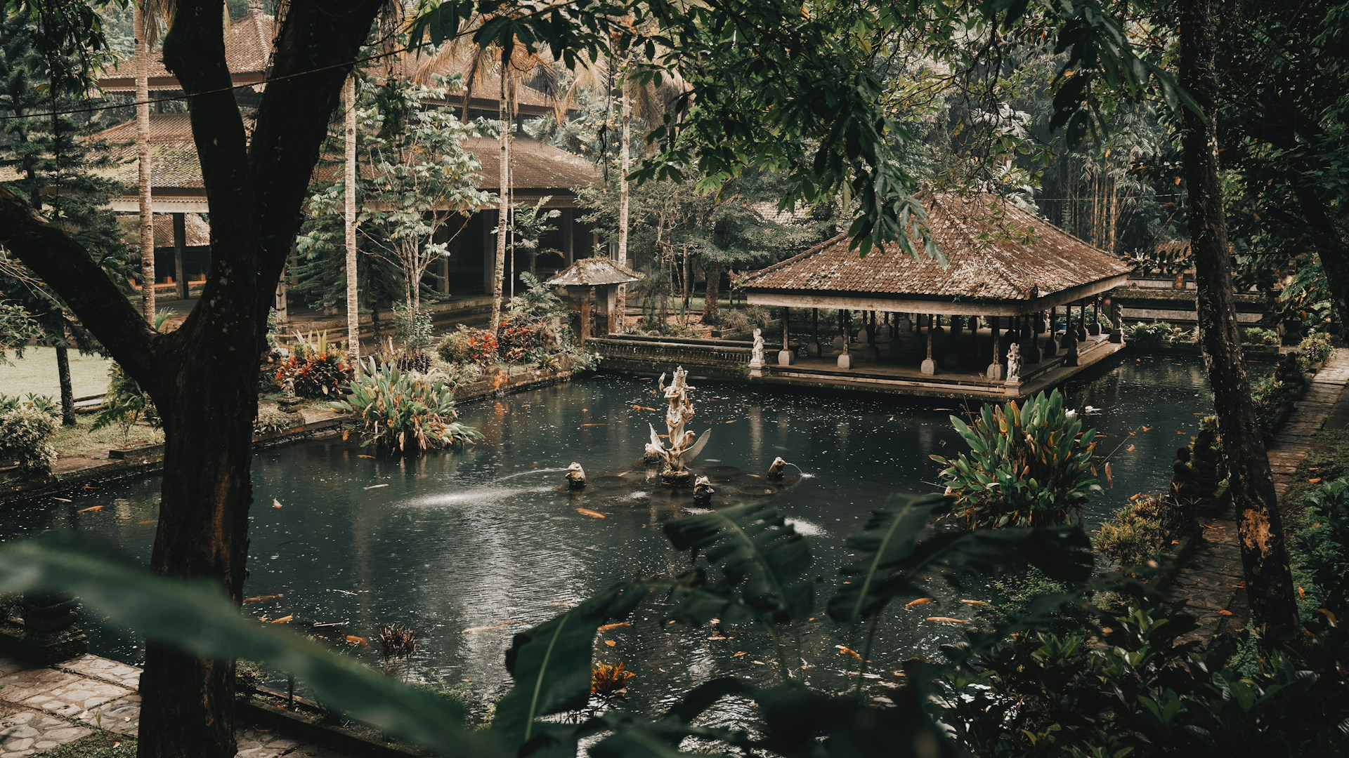 a pond surrounded by trees with a gazebo in the middle