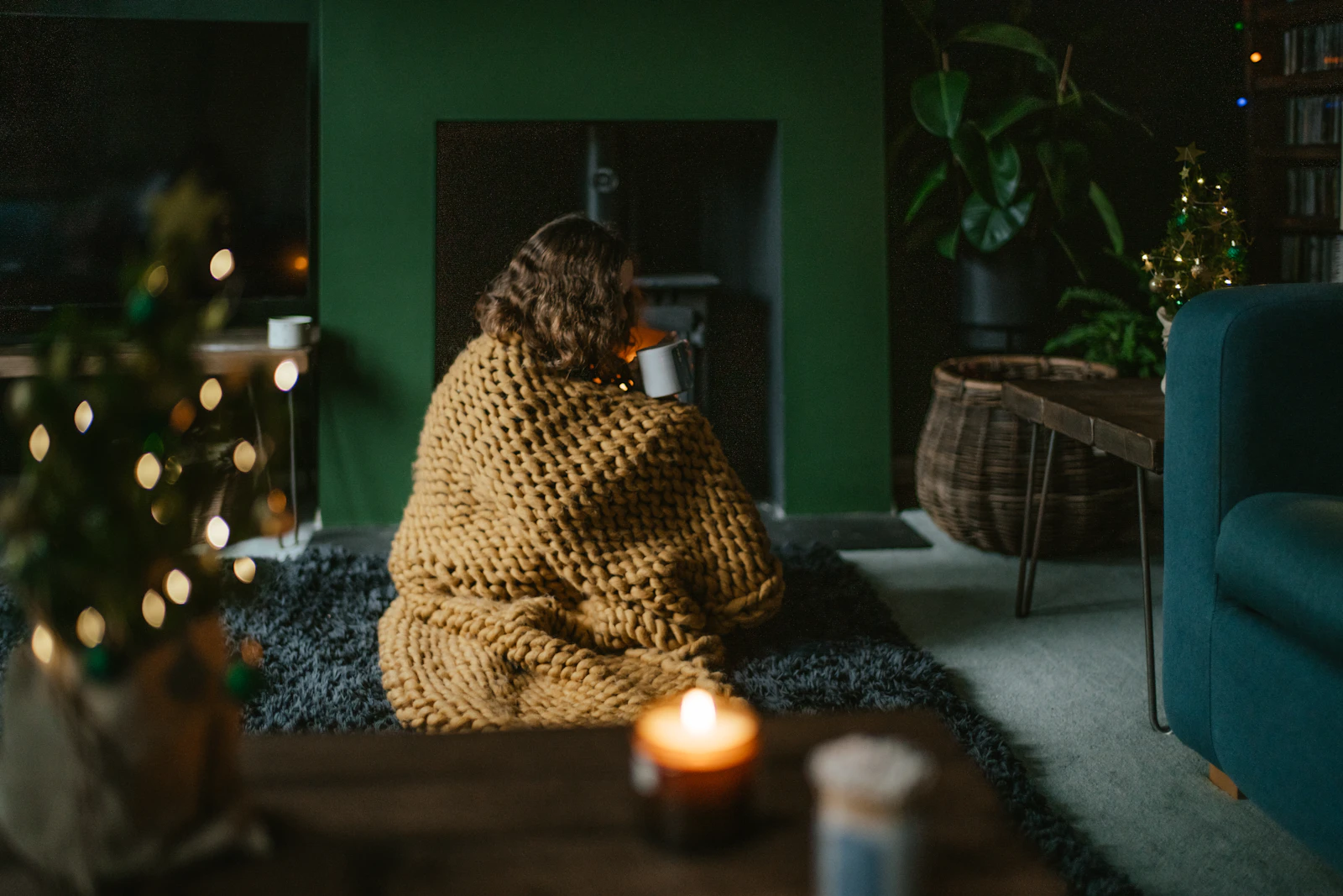 A woman wrapped in a blanket resting quietly at home