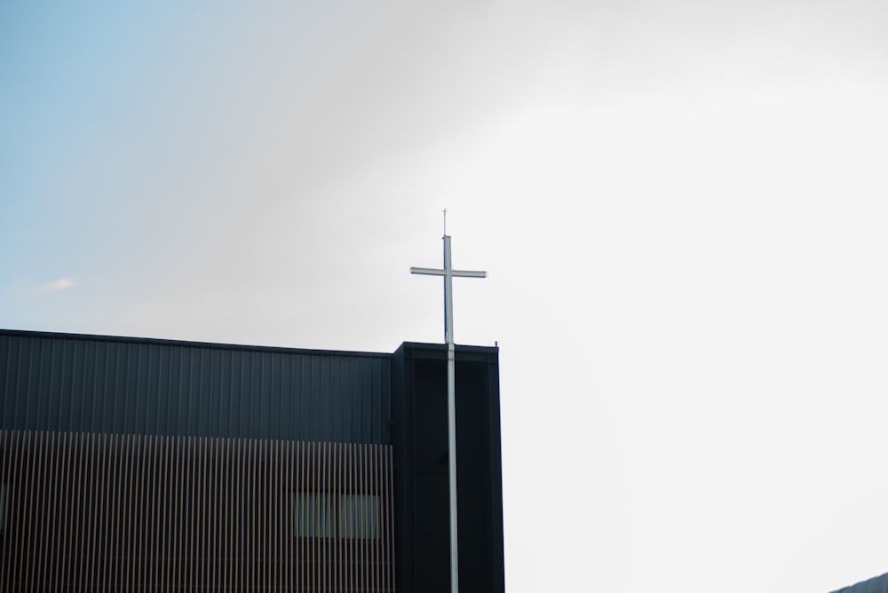 a cross on top of a building with a sky background