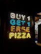 a neon sign that says buy 1 get 1 free pizza